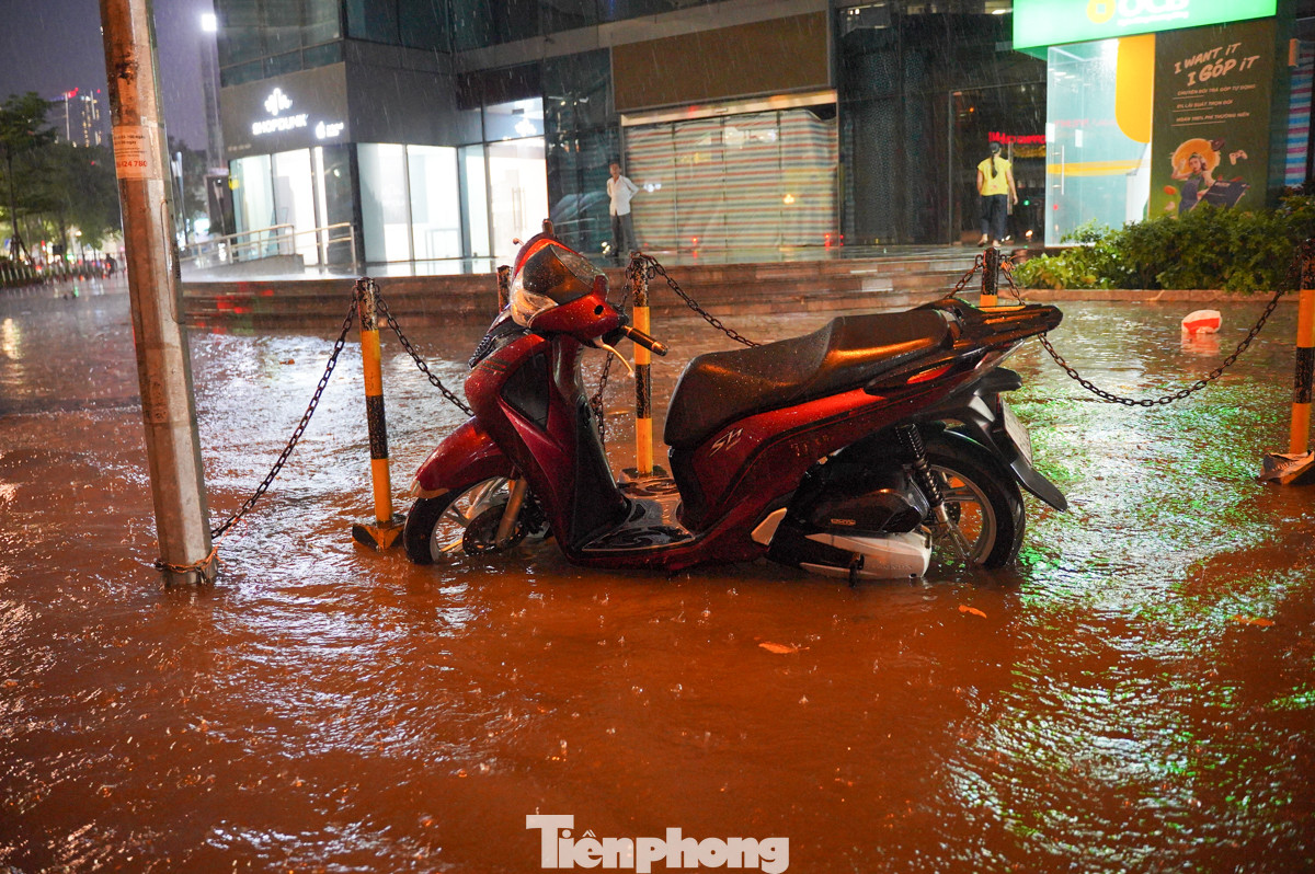 Mặc dù nhiều xe máy đã được để lên vỉa hè, nhưng theo quan sát, nước vẫn ngập sâu đến mức che lấp cả bánh xe.