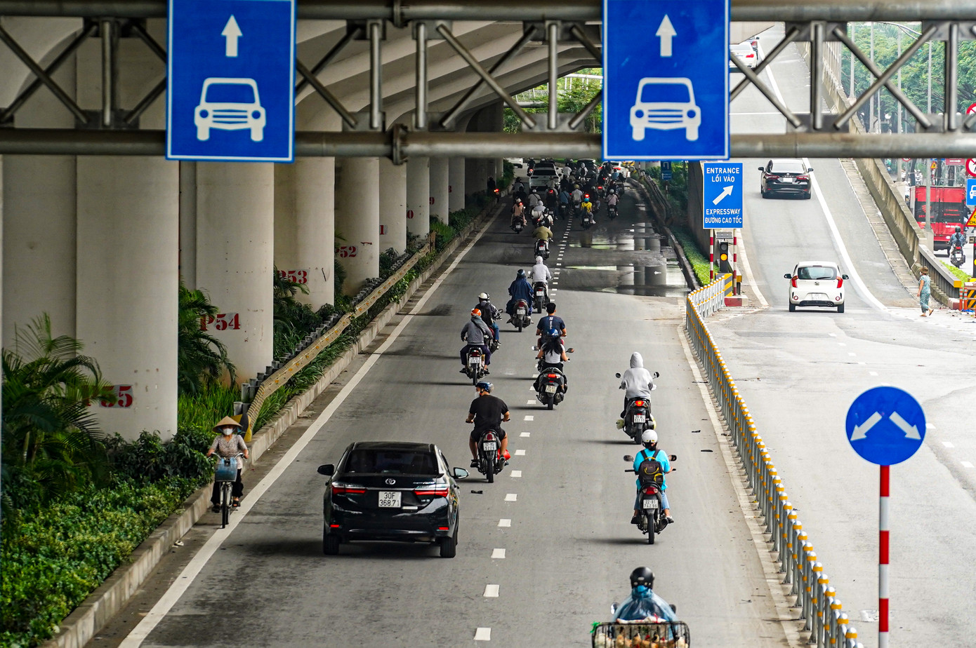 Hàng loạt xe máy nối đuôi nhau đi vào làn dành cho ô tô trên đường Phạm Văn Đồng theo thói quen.
