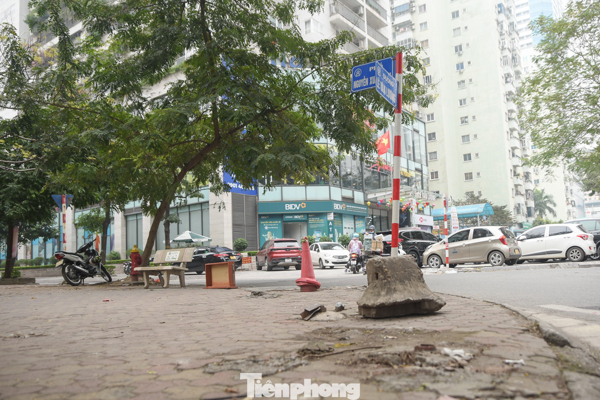 Vỉa hè trên phố Lê Văn Lương bày đủ thứ đồ để ngăn xe ôtô đi lên.