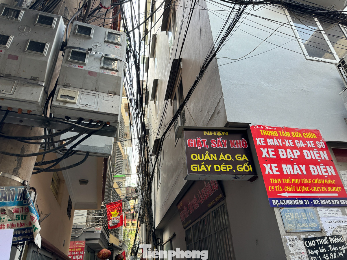Bên dưới đủ các loại dây cáp thông tin, dây điện giăng như "mạng nhện" án ngữ các điểm giao cắt trong ngõ.