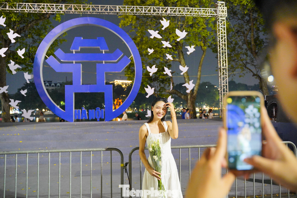 Các bạn trẻ thong thả dạo quanh Hồ Gươm, chụp ảnh với biểu tượng của Hà Nội.