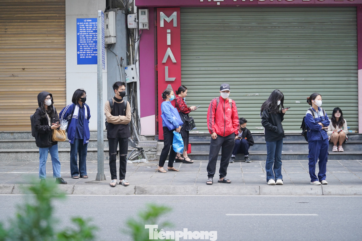 Những người đứng chờ tại các trạm xe buýt đều chuẩn bị áo ấm đối phó với gió lạnh đầu mùa.