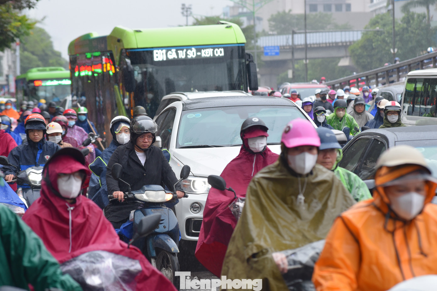 Dòng người chen nhau di chuyển trong mưa.