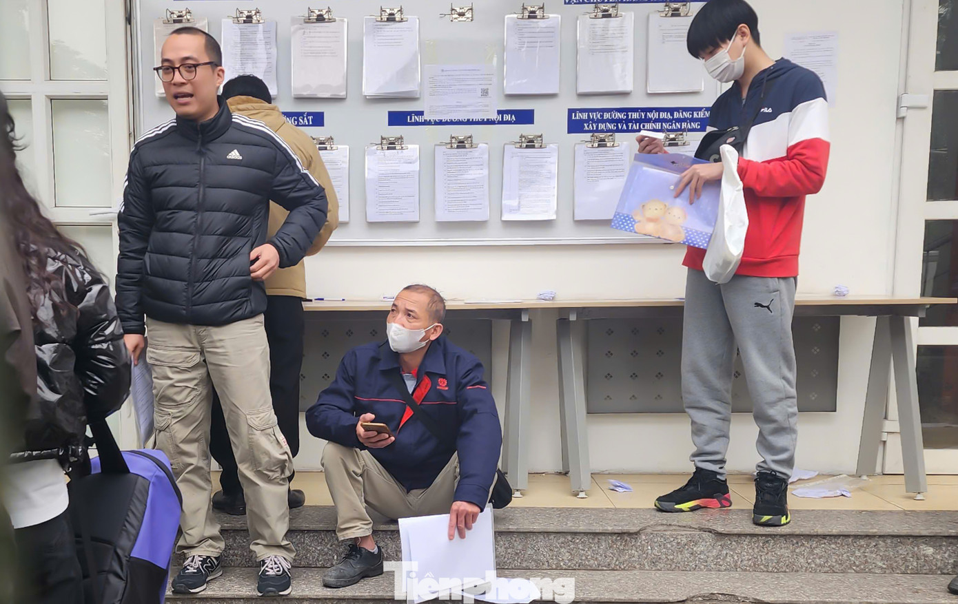 Người dân mệt mỏi sau nhiều giờ xếp hàng chờ đợi.