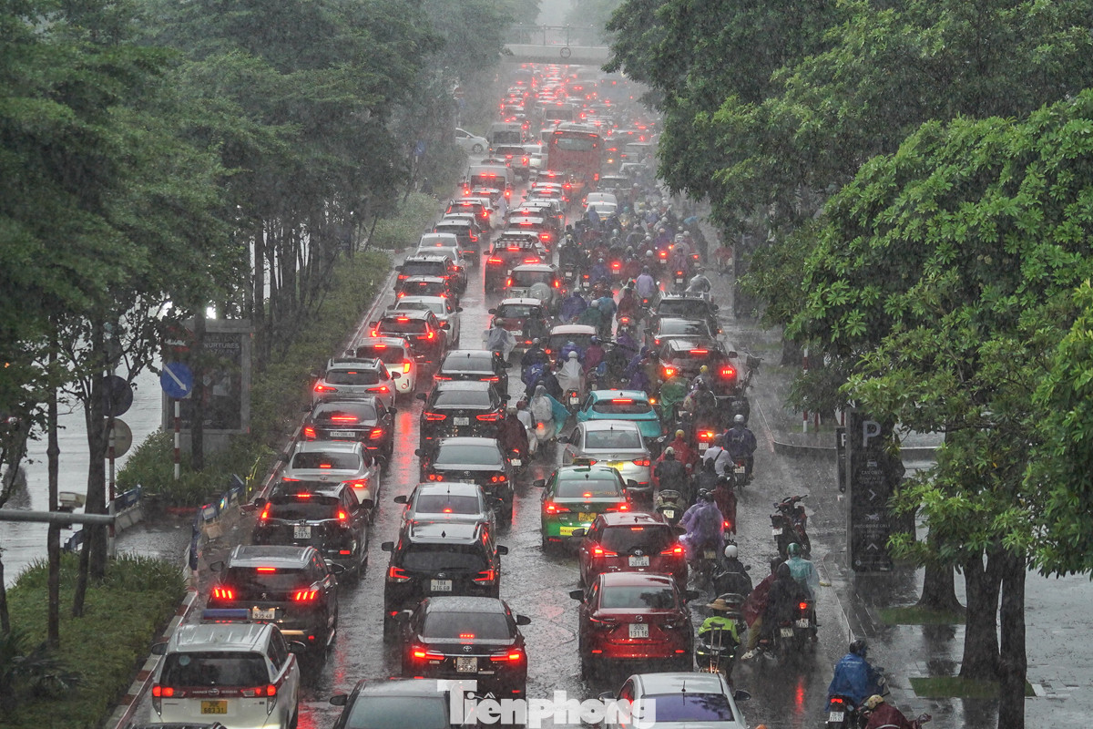 Dòng xe ô tô đan xen với xe máy nối đuôi nhau tìm đường về nhà dưới cơn mưa tầm tã, mờ mịt trên đường Đào Tấn lúc 18 giờ.