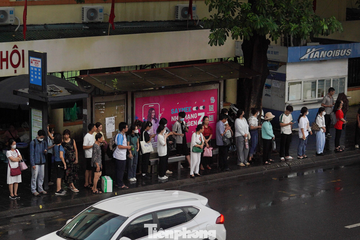 Trời mưa, đường tắc khiến những người chờ xe buýt phải đợi lâu hơn.