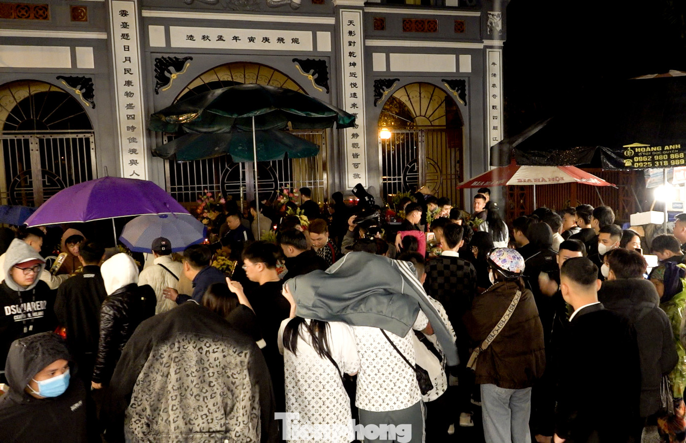 Người cầm ô, người lấy áo che mưa để tiến hành dâng lễ ngoài cửa Phủ