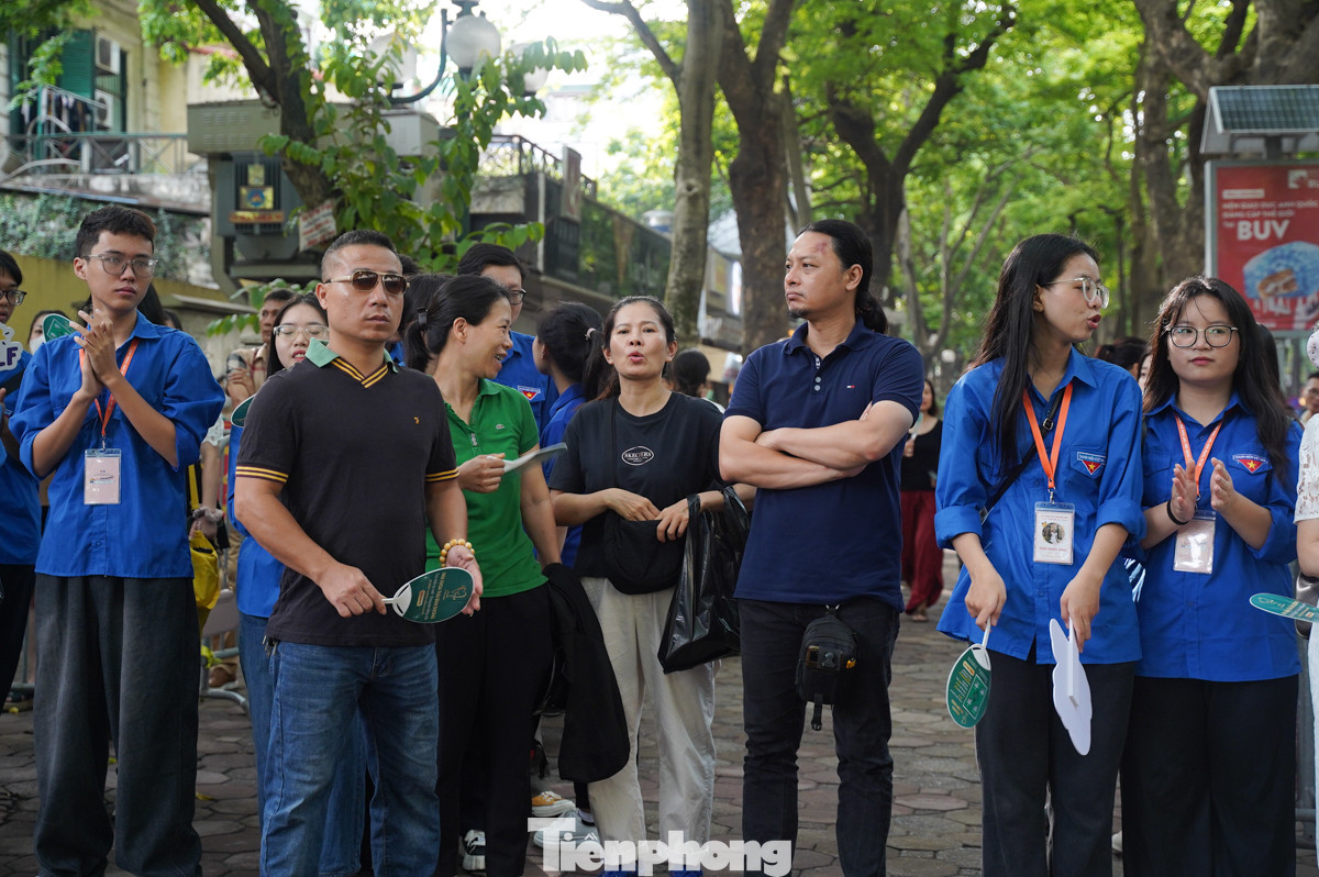 Phía bên ngoài cổng trường, các phụ huynh đứng chờ con thi.