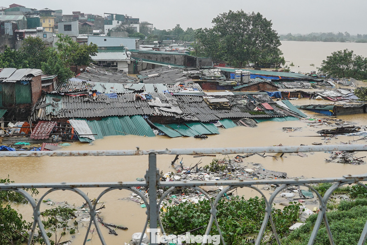Do mực nước sông Hồng dâng cao những ngày qua nên một số ngôi nhà dưới chân cầu Long Biên ngập sâu.