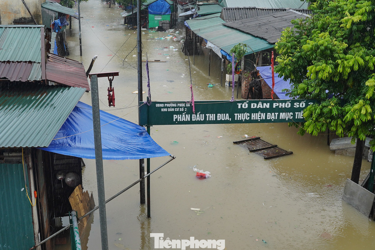 Do mực nước sông Hồng dâng cao những ngày qua nên một số ngôi nhà dưới chân cầu Long Biên ngập sâu.