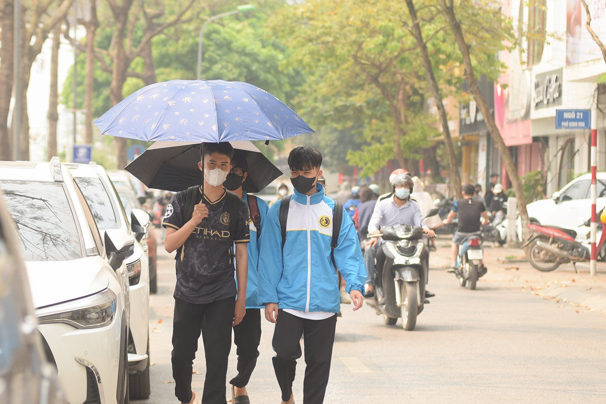 Các bạn sinh viên che ô khi tan học vì thời tiết nắng nóng.