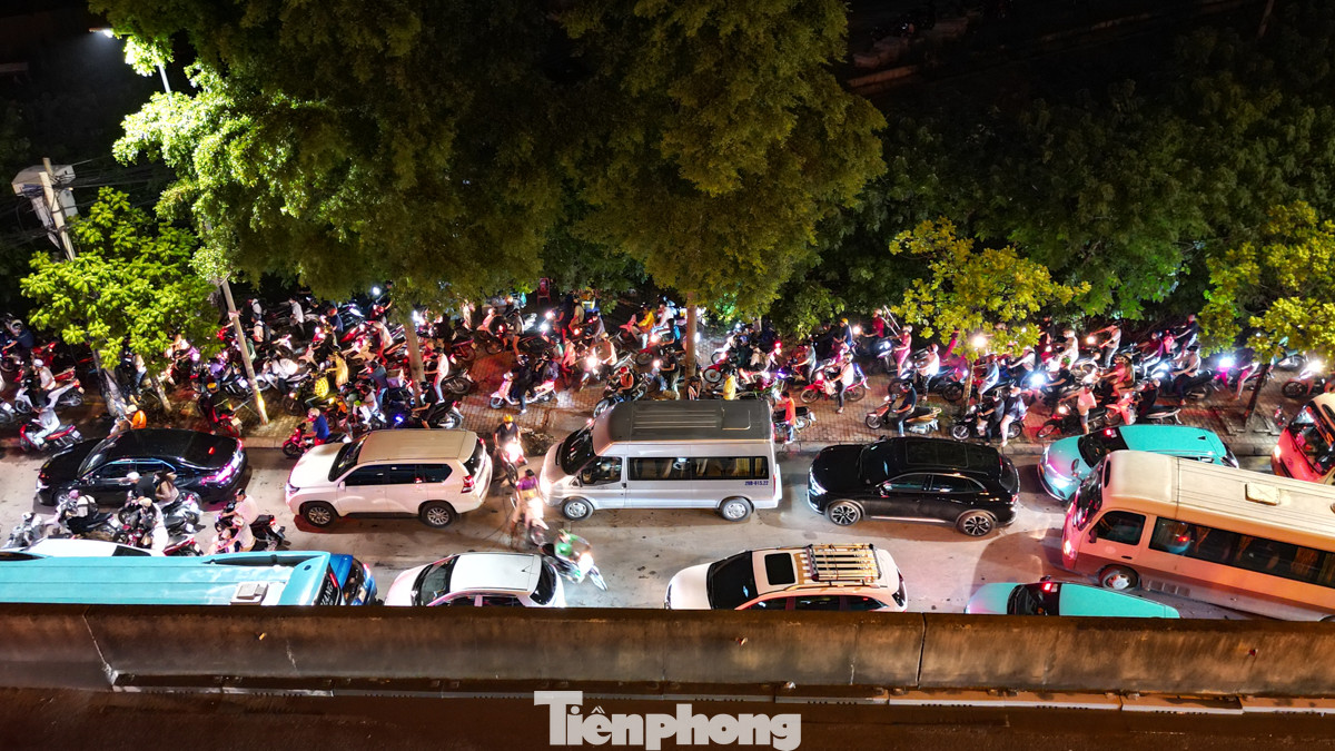 Bên dưới người đi xe máy phải luồn lách, leo vỉa hè để mong về nhà sớm.