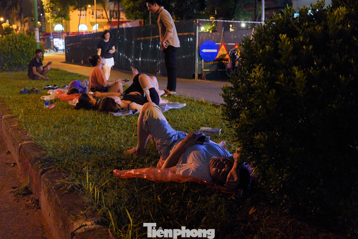 Một số người vạ vật nằm chờ trên giải phân cách giao thông.