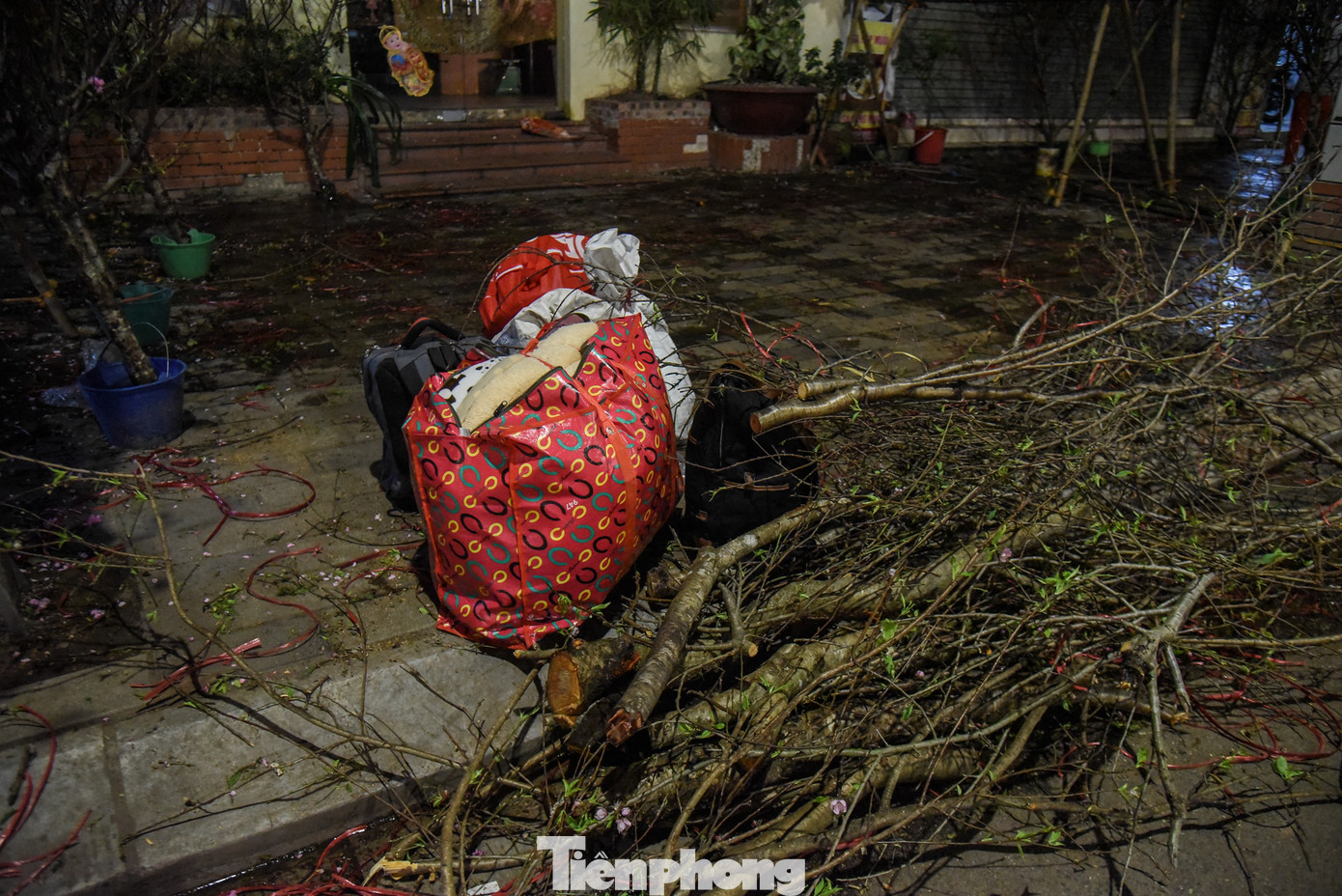 Bên cạnh những cành đào là những túi quần áo, đồ dùng cá nhân của tiểu thương. Để bán hàng Tết, một số người đã ngủ "màn trời chiếu đất" suốt 1 tháng qua trên vỉa hè Hà Nội.