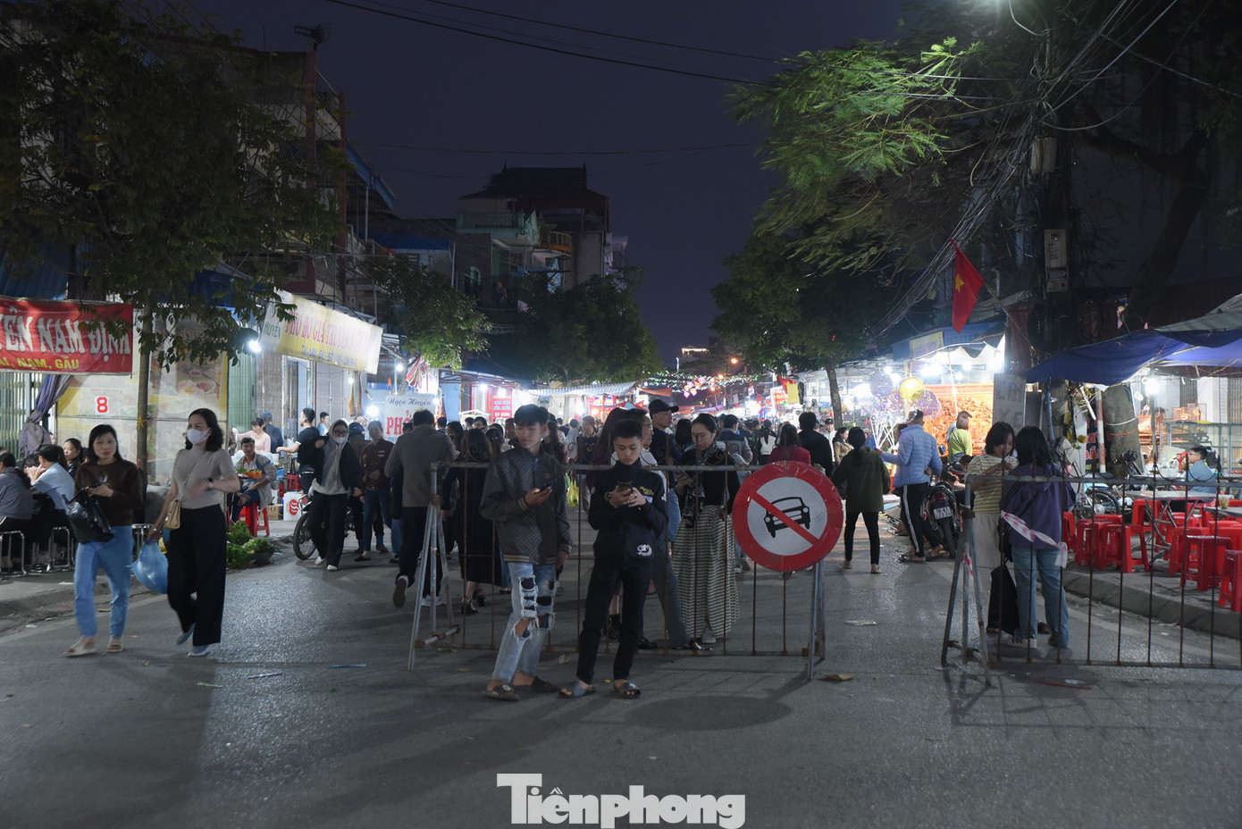 Chưa đến giờ họp chợ, thế nhưng nhiều người đã đến sớm để mua đồ. Tại chợ Viềng, người dân bày bán nông cụ, vật dụng làm nông nghiệp từ dao, liềm, cuốc, xẻng... đến cây hoa màu, cây cảnh. Trong ảnh: du khách mua hàng ở chợ Viềng để cầu may dịp đầu năm.