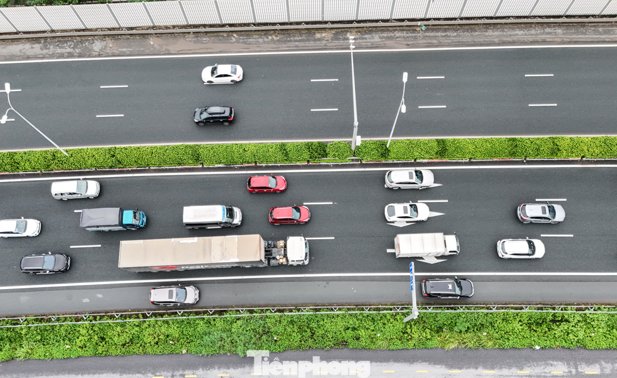 Phía sau, từng dòng phương tiện di chuyển chậm trên cao tốc Pháp Vân - Cầu Giẽ.
