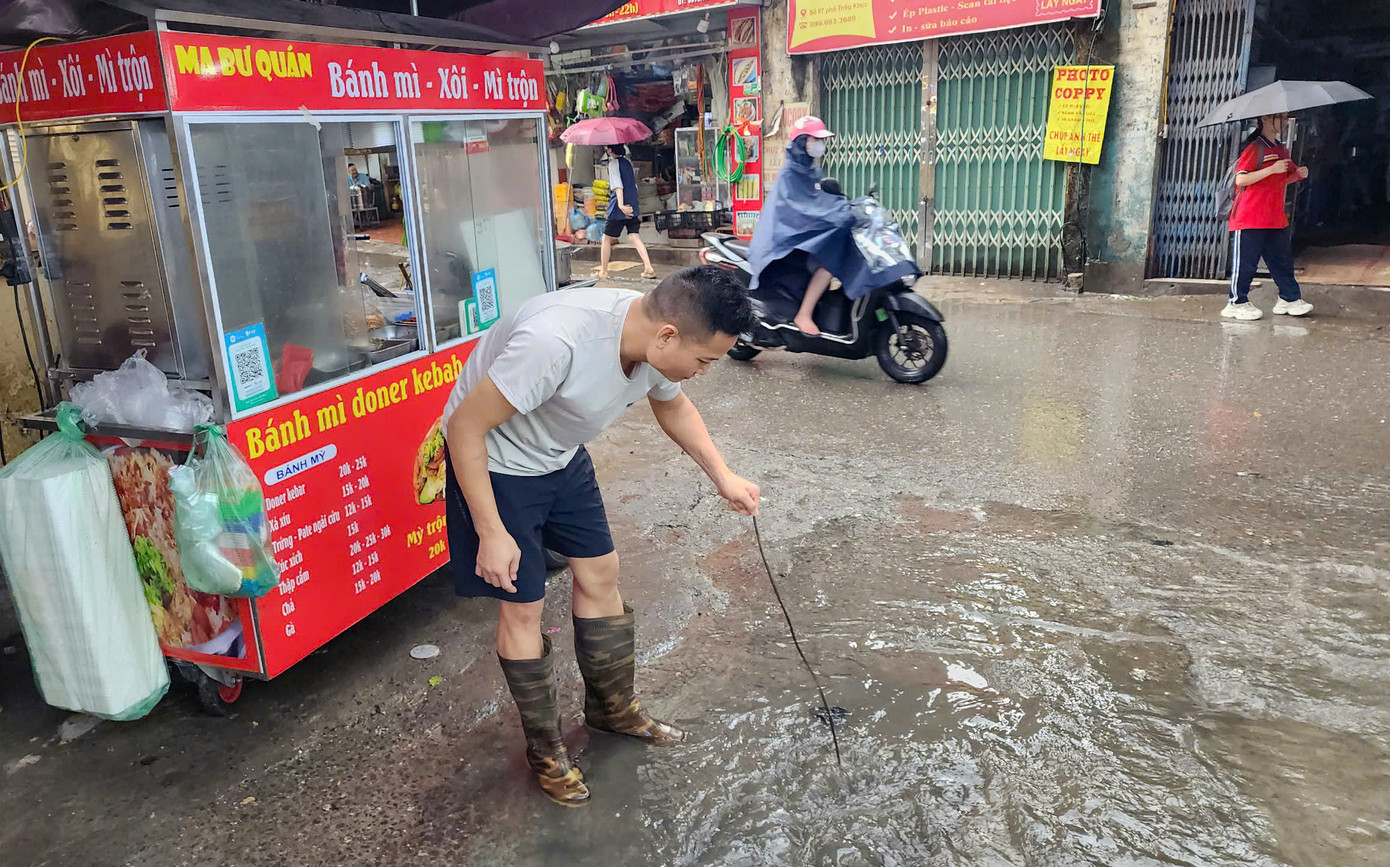 Một số người dân thông cống để nước rút nhanh hơn.