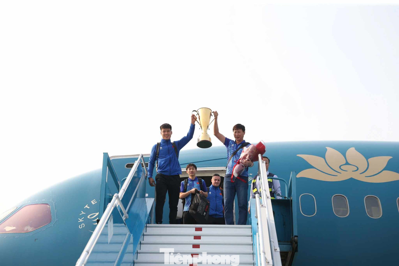 Các cầu thủ tuyển Việt Nam xuống máy bay, cầm theo chiếc cup vô địch trong không khí hân hoan.