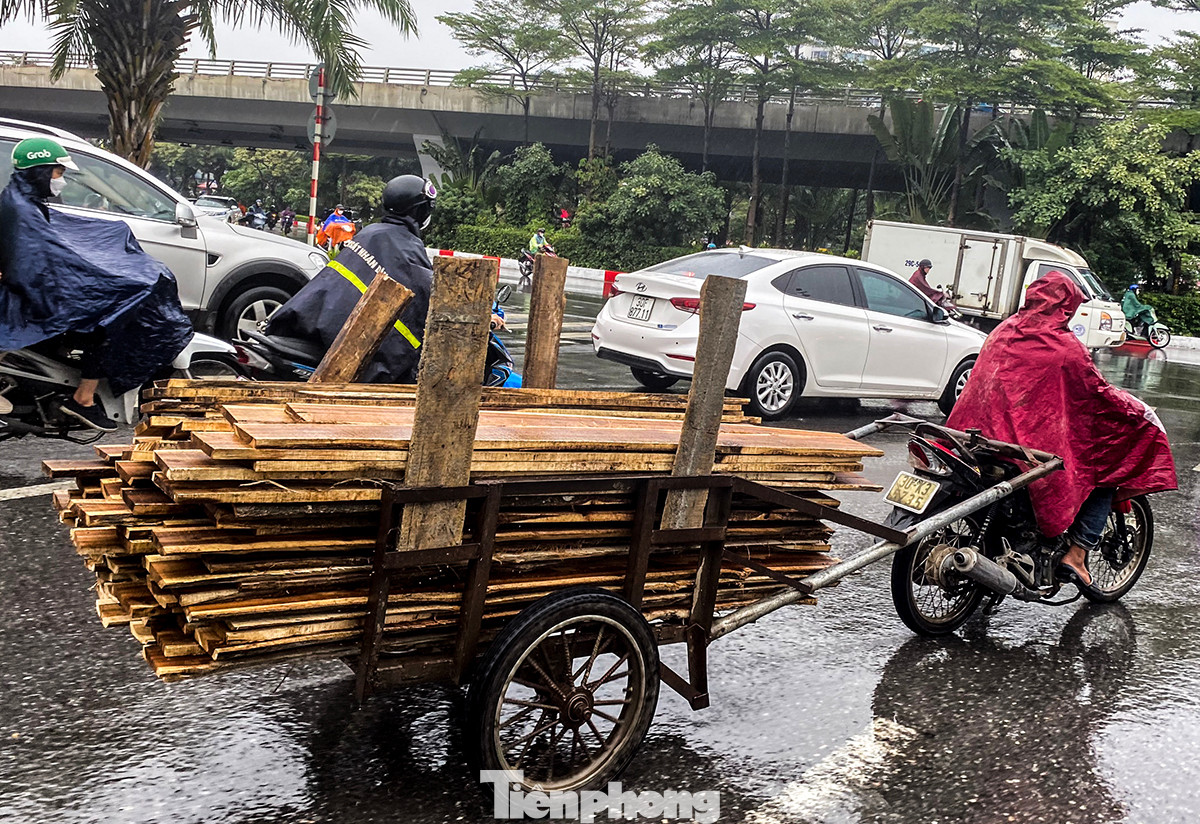 Ghi nhận sáng 1/12, dù trời mưa tầm tã, các phương tiện chở hàng cồng kềnh vẫn xuất hiện rất nhiều trên đường phố Hà Nội. Đường trơn trượt, đầu và cuối xe không có vật liệu che chắn, cảnh báo cho người đi đường. Ghi nhận sáng 1/12, dù trời mưa tầm tã, các phương tiện chở hàng cồng kềnh vẫn xuất hiện rất nhiều trên đường phố Hà Nội. Đường trơn trượt, đầu và cuối xe không có vật liệu che chắn, cảnh báo cho người đi đường.