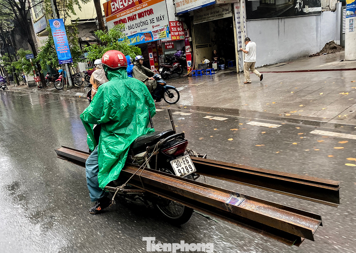Ghi nhận sáng 1/12, dù trời mưa tầm tã, các phương tiện chở hàng cồng kềnh vẫn xuất hiện rất nhiều trên đường phố Hà Nội. Đường trơn trượt, đầu và cuối xe không có vật liệu che chắn, cảnh báo cho người đi đường. Ghi nhận sáng 1/12, dù trời mưa tầm tã, các phương tiện chở hàng cồng kềnh vẫn xuất hiện rất nhiều trên đường phố Hà Nội. Đường trơn trượt, đầu và cuối xe không có vật liệu che chắn, cảnh báo cho người đi đường.