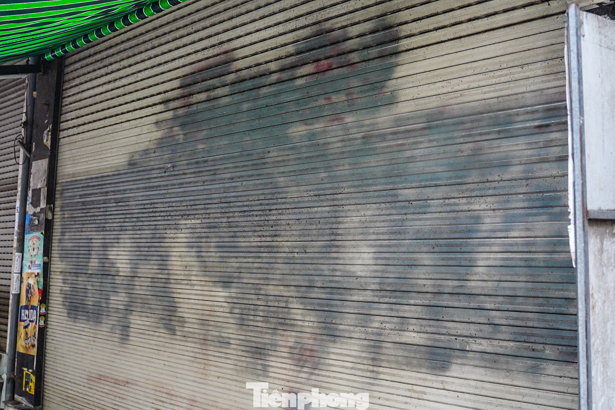 Một số hộ dân dùng mọi cách từ xà phòng, nước lau kính, cồn... để xoá những nét vẽ. Và kết quả để lại là cửa cuốn nhằng nhịt vết sơn đen.