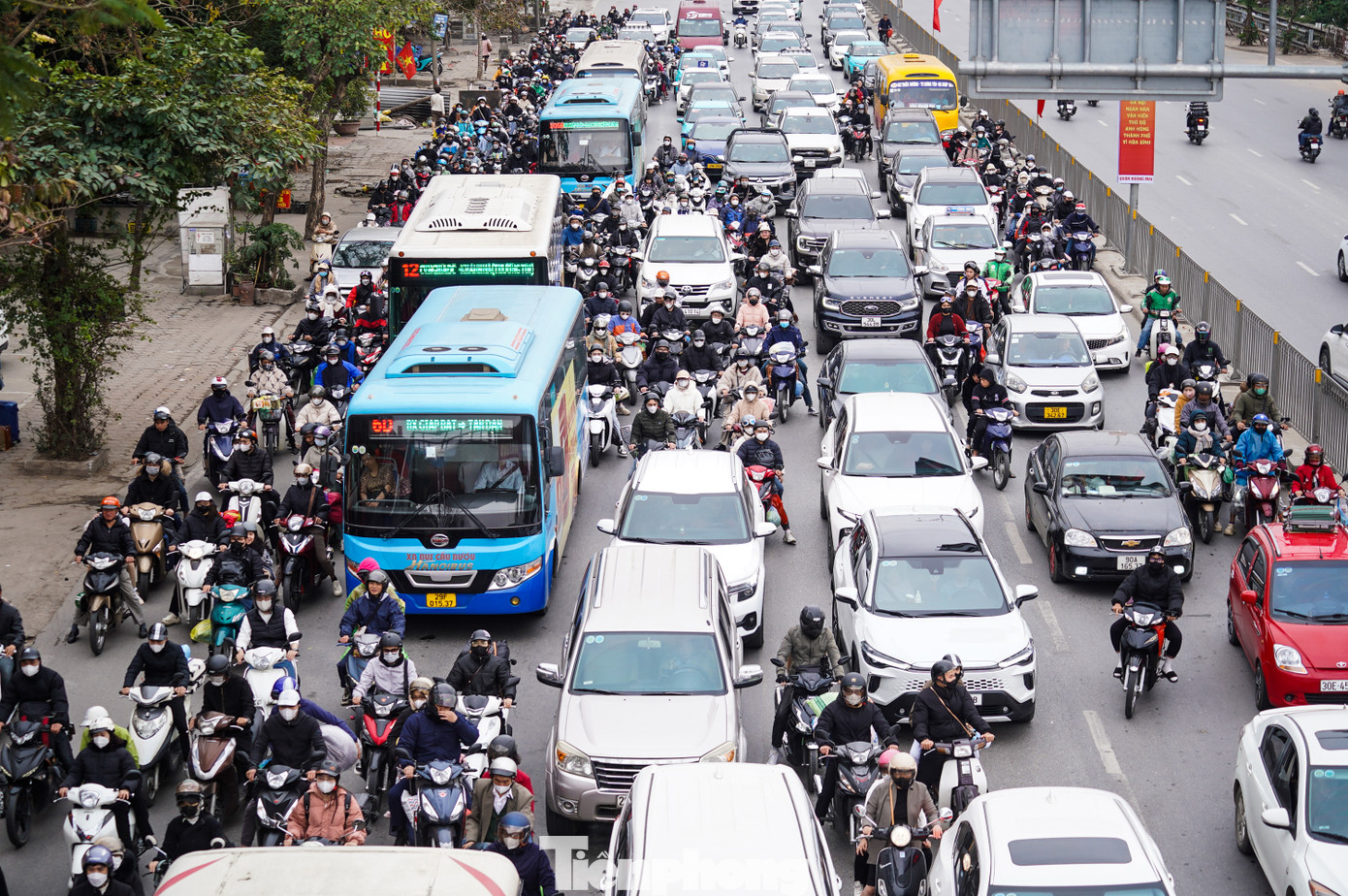 Người và phương tiện với hành lý, vali, đồ đạc từ hướng QL1A di chuyển về trung tâm Hà Nội chiều mùng 5 Tết.
