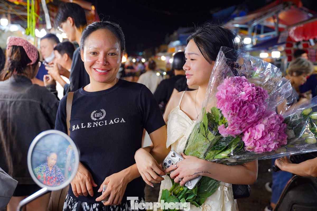 Hai mẹ con dẫn nhau đi tận hưởng không khí chợ đêm, chọn lựa một bó hoa tươi thắm nhất để mang về.