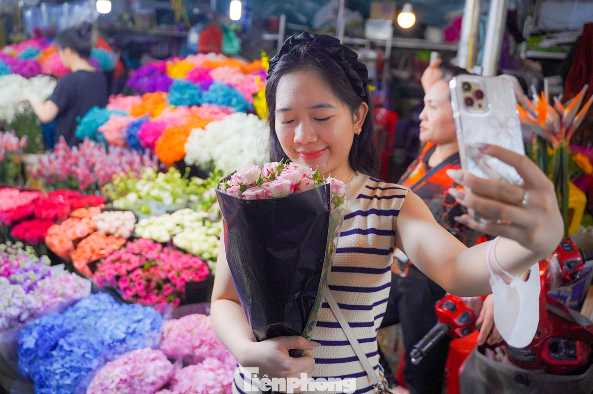 Chị Liên (quận Thanh Xuân, thành phố Hà Nội) đứng nép vào một quầy hoa để tự chụp ảnh kỷ niệm cho bản thân. “Là phụ nữ, tự dành tặng cho mình bó hoa vào dịp này cũng ý nghĩa mà, quan trọng là niềm vui và hạnh phúc".