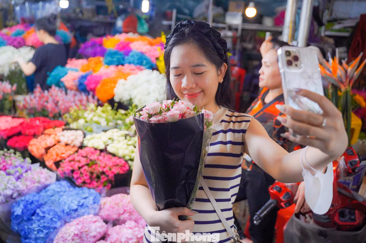 Chị Liên (quận Thanh Xuân, thành phố Hà Nội) đứng nép vào một quầy hoa để tự chụp ảnh kỷ niệm cho bản thân. “Là phụ nữ, tự dành tặng cho mình bó hoa vào dịp này cũng ý nghĩa mà, quan trọng là niềm vui và hạnh phúc".