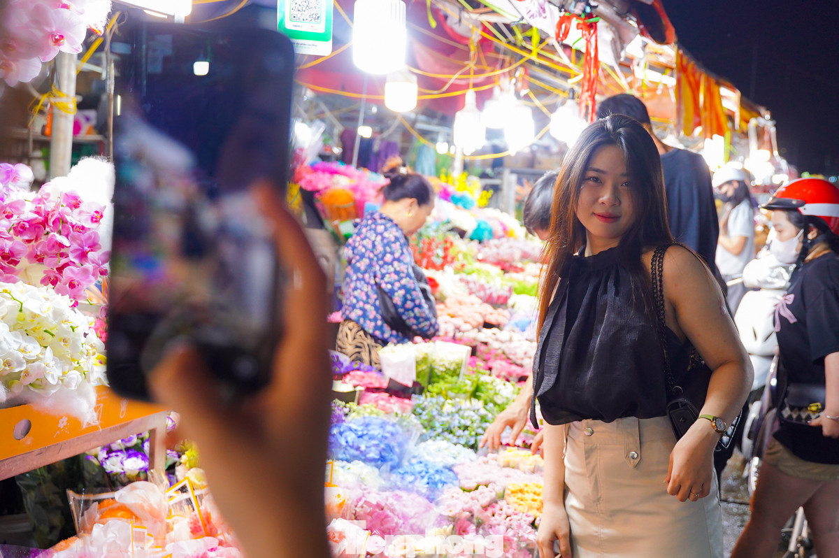Nhiều bạn trẻ tranh thủ ghi lại những bức ảnh kỷ niệm giữa rừng hoa rực rỡ muôn màu sắc. "Mình rất thích khung cảnh chợ hoa đêm Quảng Bá những ngày này, nhộn nhịp nhưng không kém phần lãng mạn", bạn nữ chia sẻ.