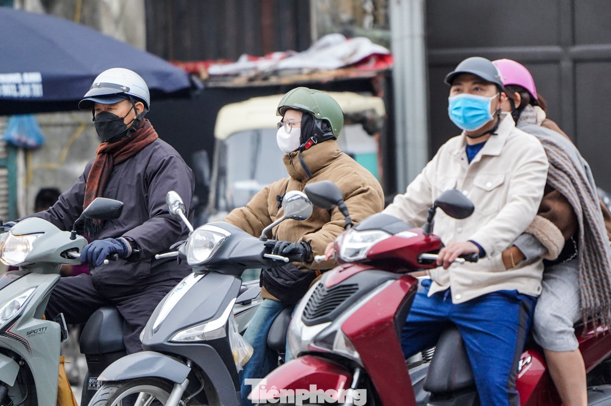 Để đối phó với gió lạnh, ngoài áo ấm, người dân ra đường cũng không quên tự trang bị khăn, mũ, khẩu trang...