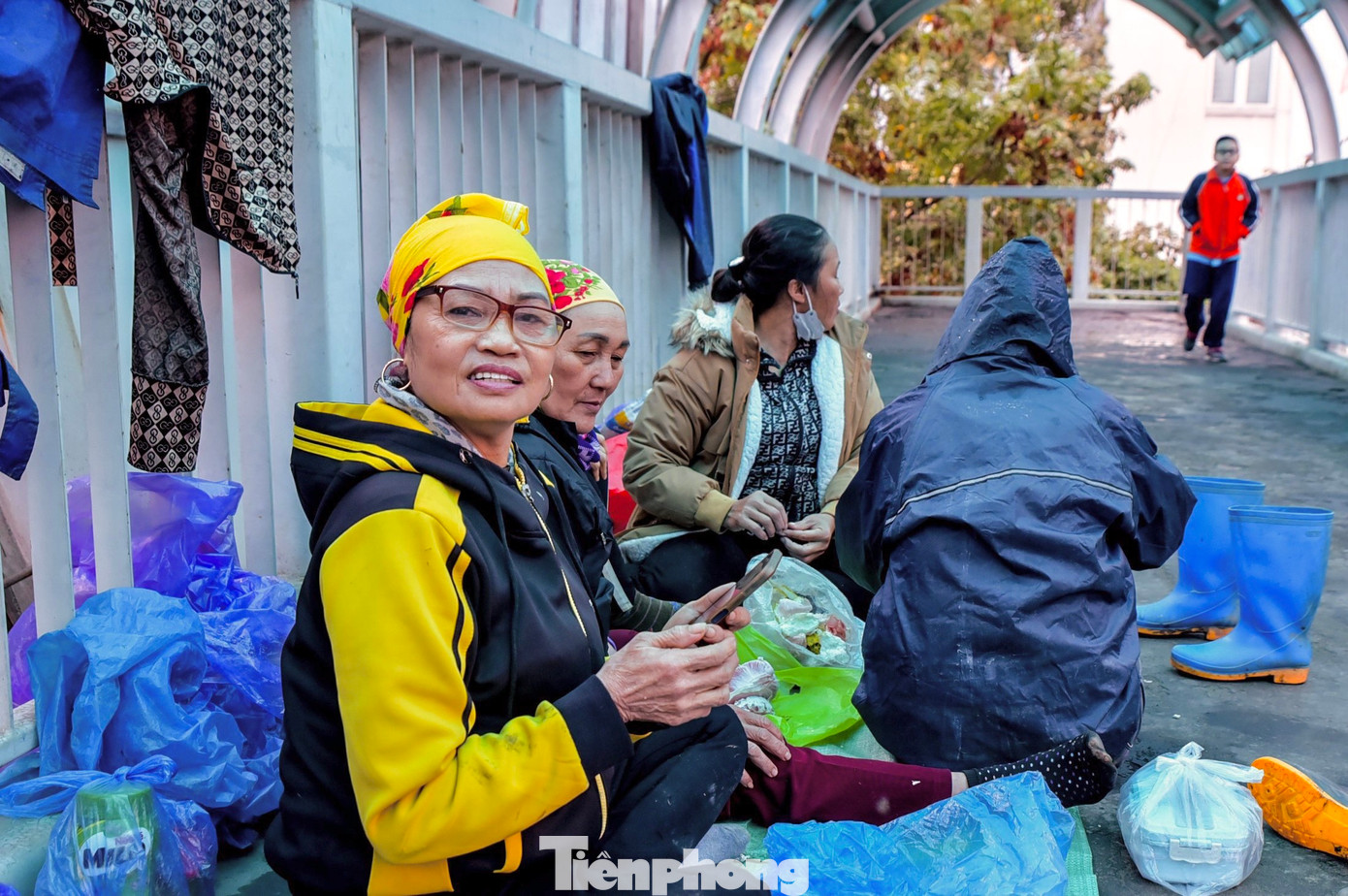 Cô Đỗ Thị Hà - người làm nghề trồng cây, hoa ven đường, giờ nghỉ trưa, tranh thủ cô và các đồng nghiệp lên cầu vượt nghỉ ngơi, tránh mưa. "Thời tiết mưa công việc vất vả hơn rất nhiều, đất rất dơ, khó làm. Khi mưa chúng tôi phải trang bị áo mưa, thuốc cảm để đảm bảo tốt hơn cho công việc", cô Hà nói.