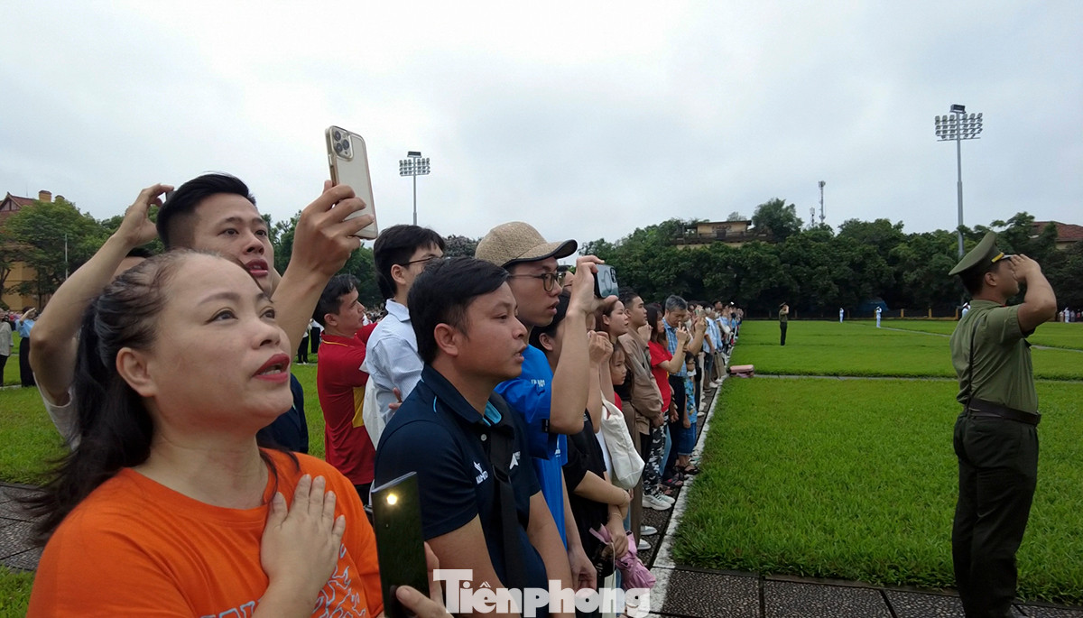 Người dân hát Quốc ca trong lễ chào cờ.