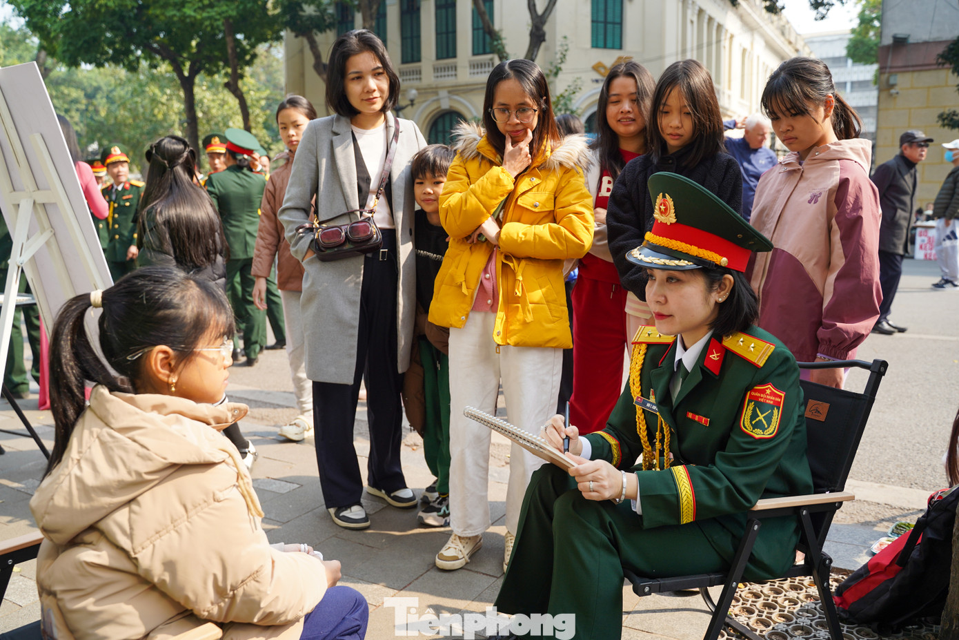 Người dân và các em nhỏ thích thú khi được các họa sĩ của Viện Thiết kế, Tổng cục Hậu cần vẽ chân dung.