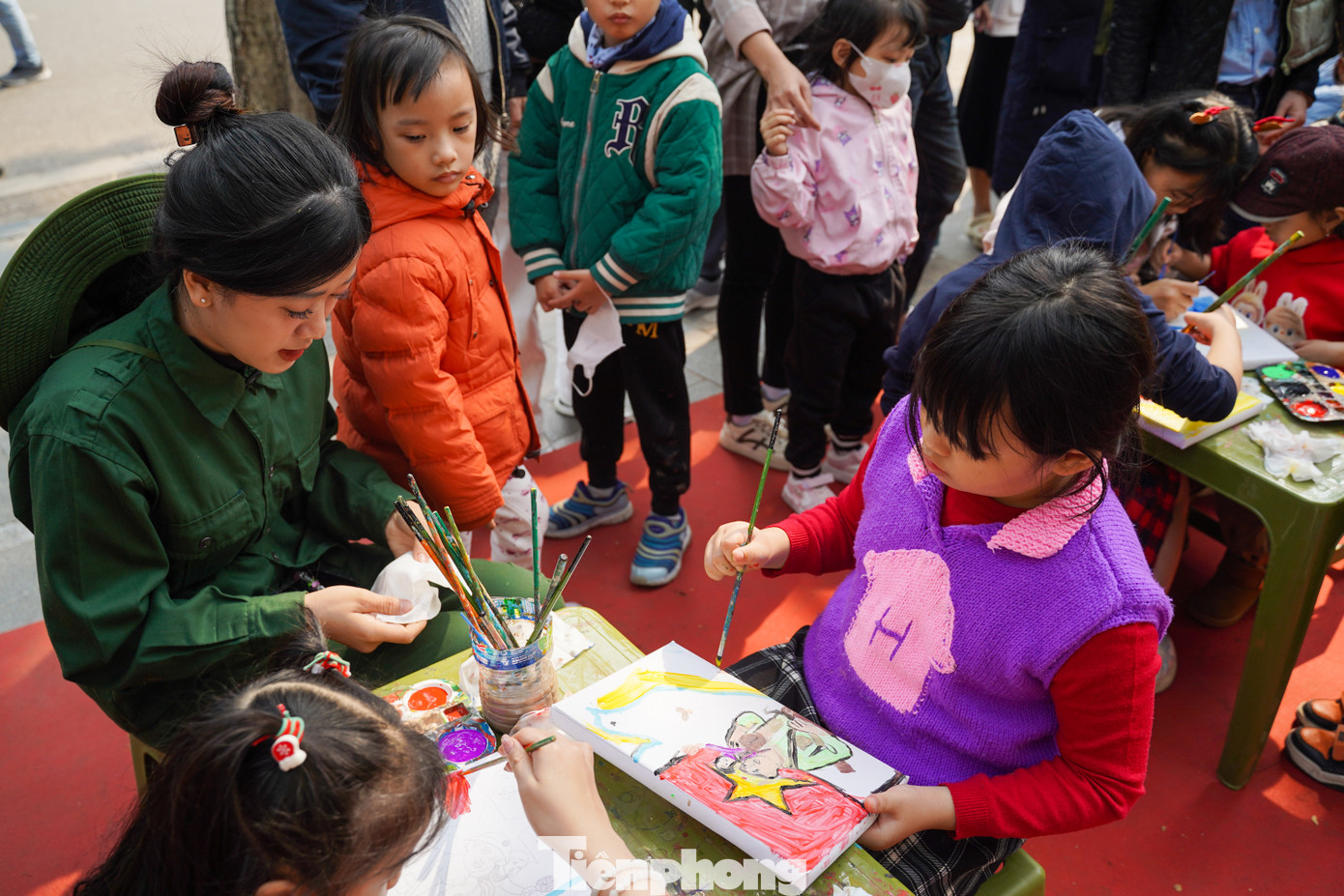 Các em nhỏ được bố mẹ dẫn đi tham quan triển lãm được trải nghiệm nhiều hoạt động thú vị như: tự tay tô tranh cổ động, chiêm ngưỡng các bức ảnh về quân đội, và đặc biệt là được các chiến sĩ tự tay vẽ chân dung của các em....