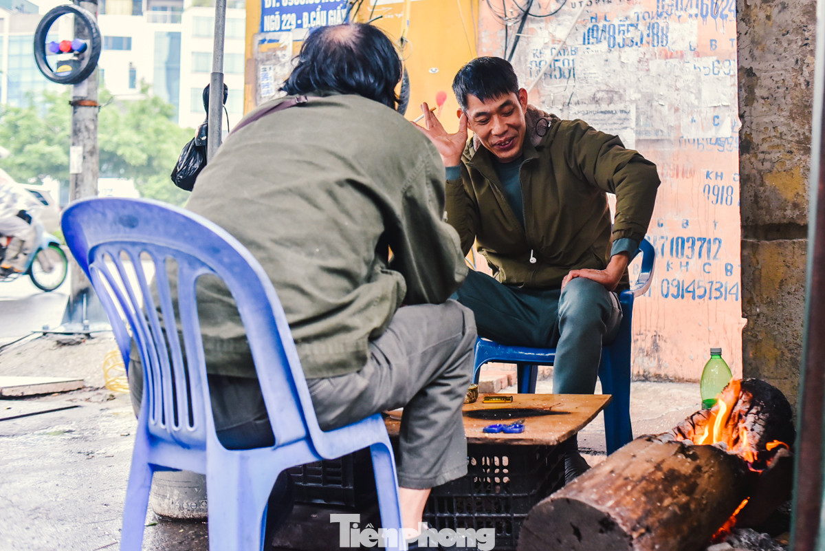 Hai người đàn ông trò chuyện phải đốt lửa sưởi ấm cho đỡ lạnh.