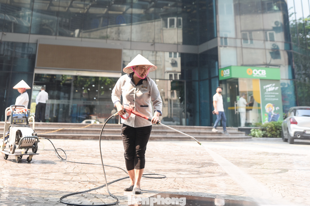 Một số chung cư ở Hà Nội phải cho nhân viên đi làm mát vỉa hè, mặt đường vì nhiệt độ càng lúc càng cao.