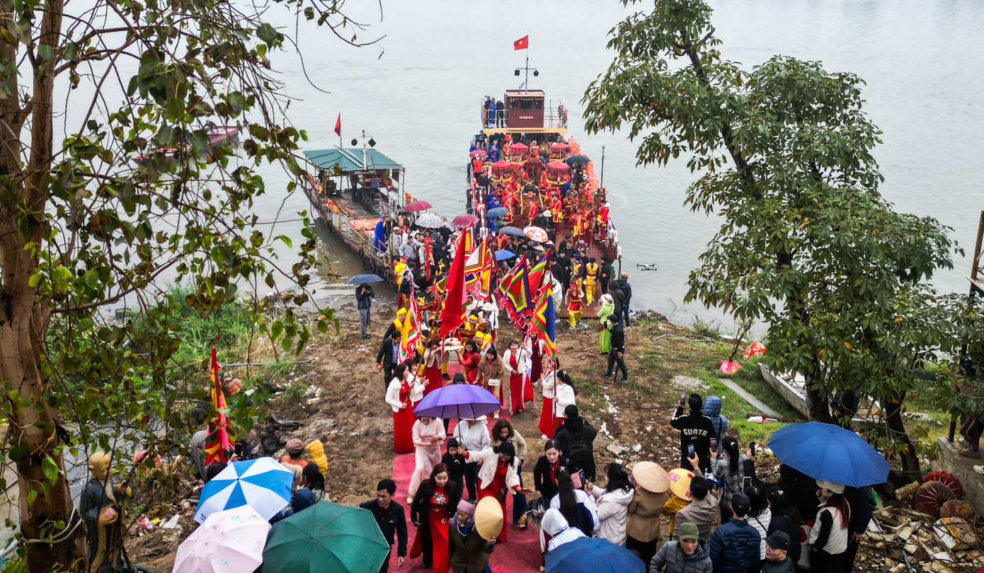 Sau khi vào bờ, kiệu và chóe di chuyển đến đâu, người dân sẽ đứng lại gần để mong được hưởng làn nước mát trong, sạch sẽ từ nguồn.