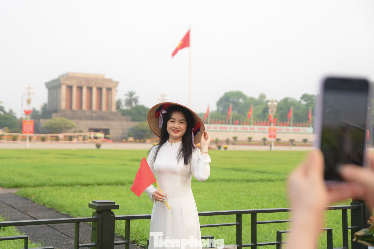 Từ sáng sớm, nhiều bạn trẻ đã diện áo dài, cầm trên tay lá cờ Tổ quốc cùng nón lá truyền thống đứng ngoài Quảng trường Ba Đình để ghi lại kỷ niệm trong dịp lễ 30/4.