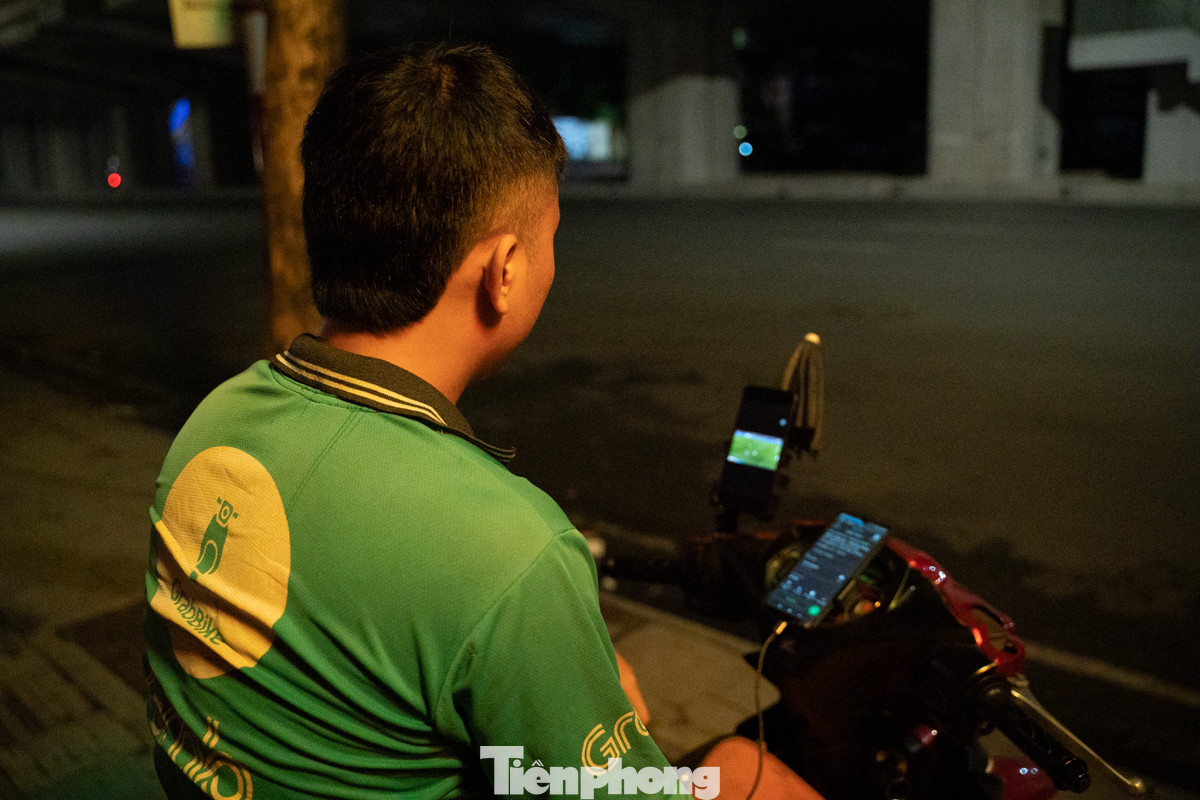 Anh Lê Viết Hiếu (một tài xế công nghệ) trong lúc chưa có khách cũng mở điện thoại ra xem Euro trên vỉa hè. &quot;Ngồi xem một tý có khách lại chạy, xem trên màn hình bé tuy không hấp dẫn nhưng có không khí là vui rồi&quot;.
