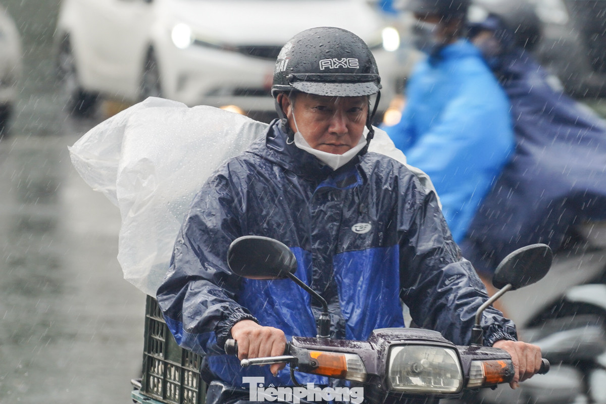 Cơn mưa sáng sớm khiến người lao động càng thêm vất vả khi di chuyển.