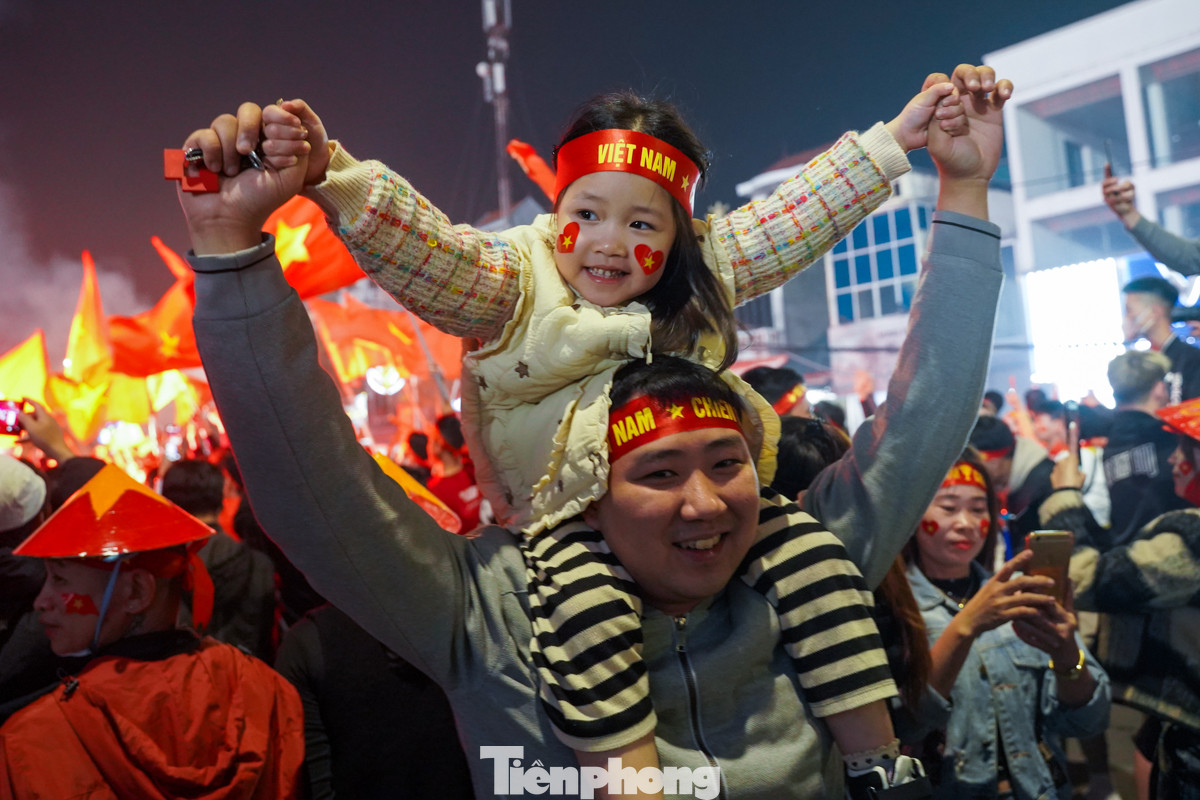 Không chỉ người lớn, trẻ em cũng được phụ huynh bế lên vai để quan sát rõ hơn và hoà mình vào chung bầu không khí ăn mừng chiến thắng.