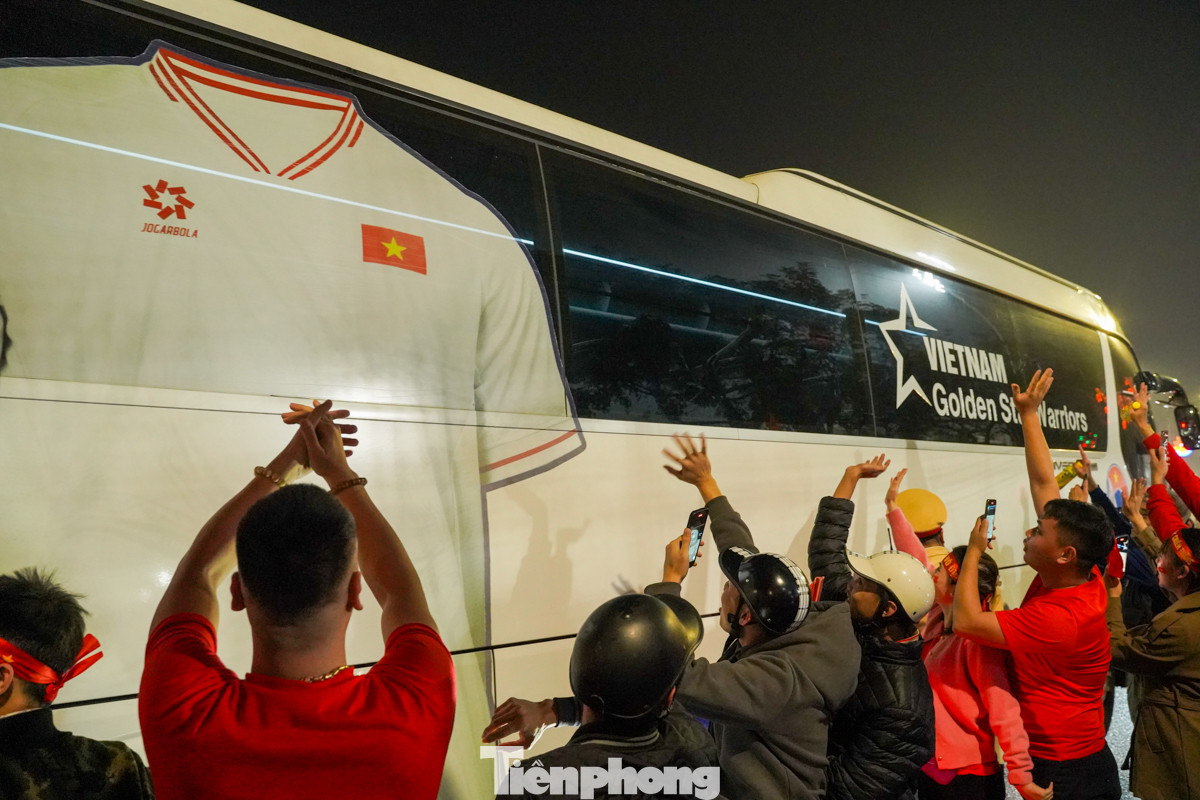 Các CĐV vẫy tay chào xe chở các cầu thủ tuyển Việt Nam đi qua trong không khí hân hoan, phấn khởi.