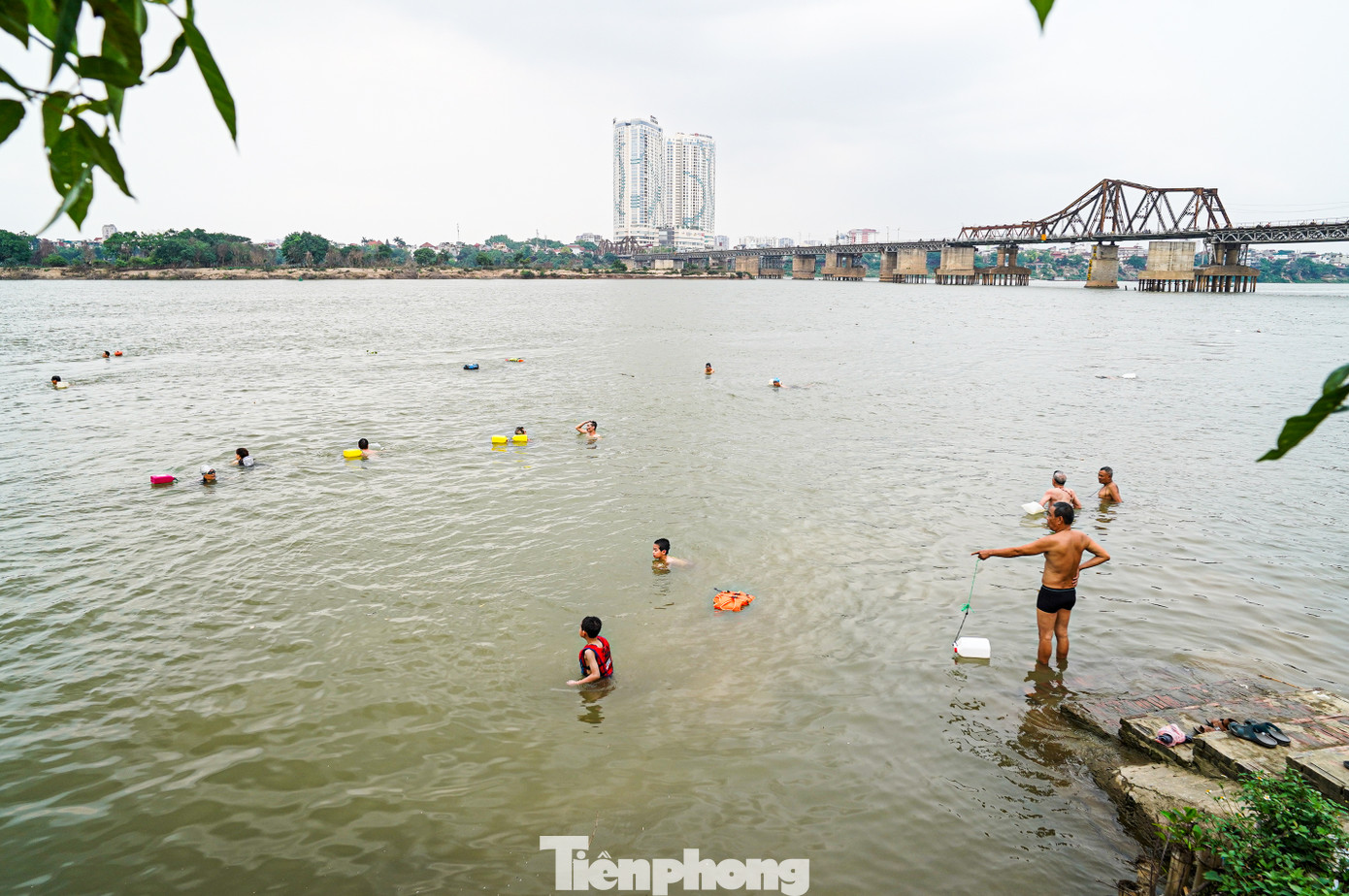Tương tự, tại bãi tắm sông Hồng ở khu vực gần chân cầu Long Biên cũng thu hút rất đông người đến giải nhiệt. Tương tự, tại bãi tắm sông Hồng ở khu vực gần chân cầu Long Biên cũng thu hút rất đông người đến giải nhiệt.
