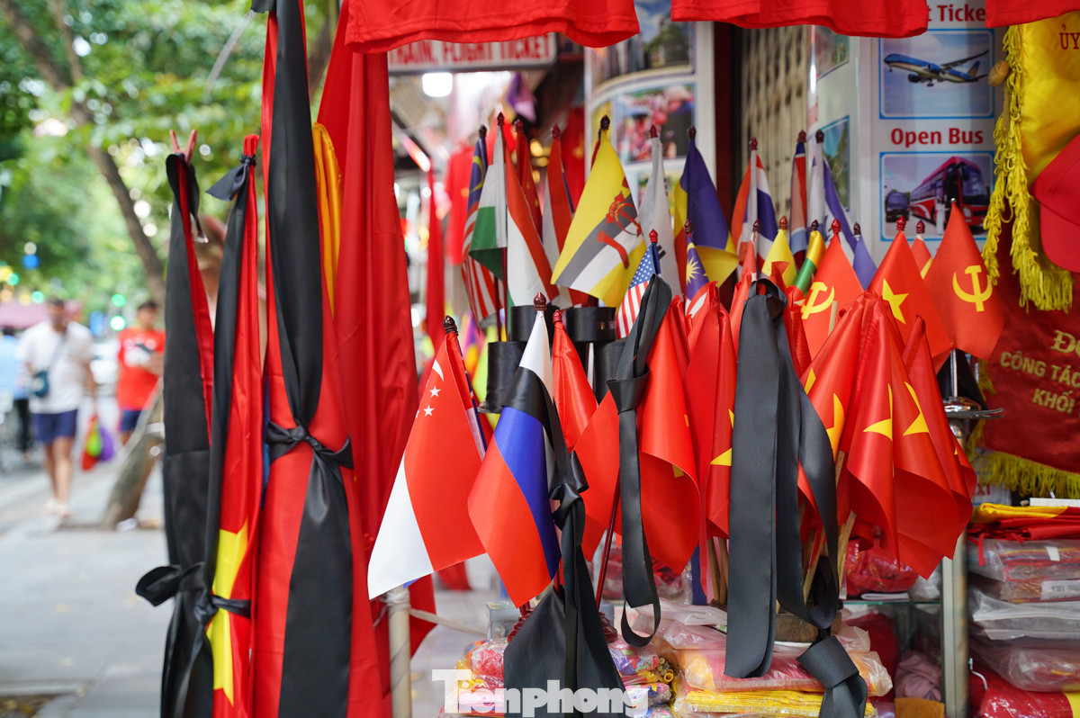 Phố Hàng Bông (quận Hoàn Kiếm) với nhiều cơ sở kinh doanh đã bày bán cờ với nhiều kích thước cùng dải băng đen để người dân treo và tưởng nhớ Tổng Bí thư Nguyễn Phú Trọng trong 2 ngày Quốc tang sắp diễn ra (25/7 và 26/7).