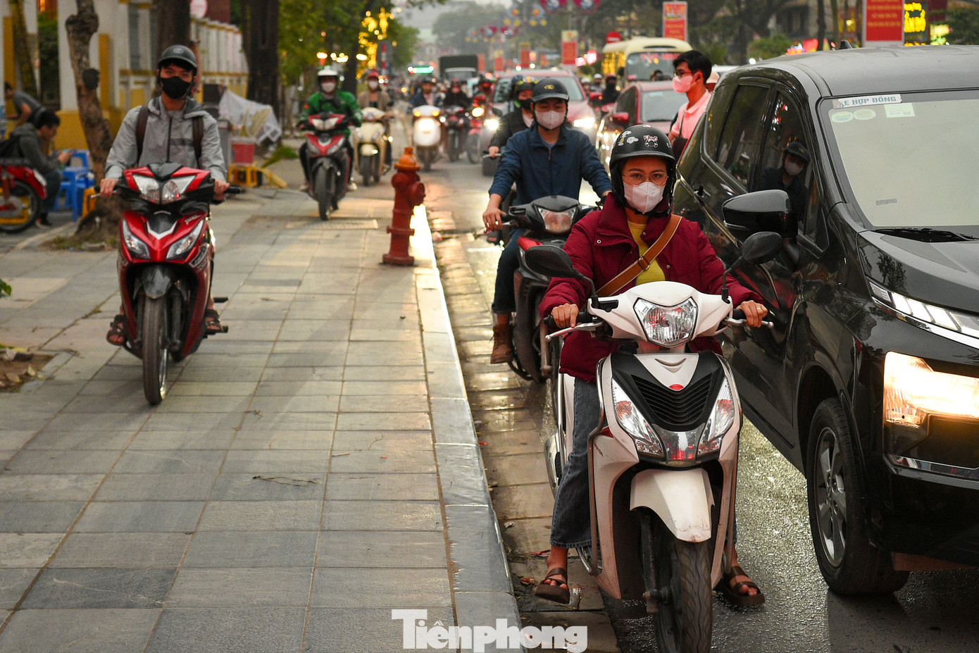 Lúc 18h, nhiều chủ phương tiện phải leo lên vỉa hè như “làn khẩn cấp”, lối đi của toà nhà hòng thoát khỏi cảnh tắc đường.