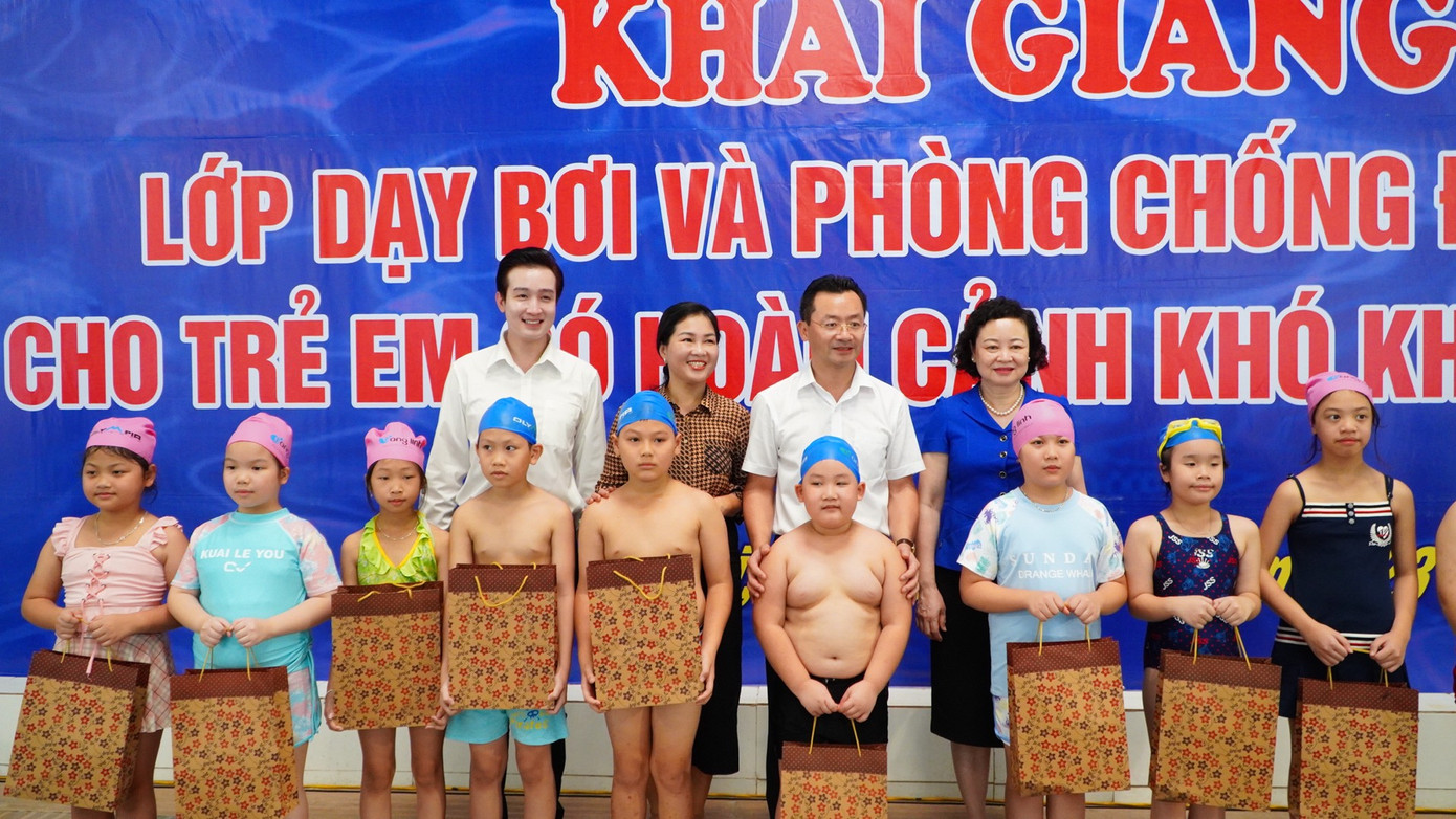 Đại diện Thành Đoàn Hà Nội và Ban tổ chức trao quà cho các em thiếu nhi có hoàn cảnh khó khăn tham gia lớp học bơi