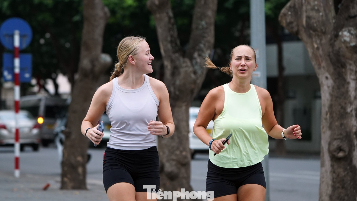 Các bạn trẻ nước ngoài thích thú khi chạy bộ quanh Hồ Gươm trong tiết trời se lạnh.