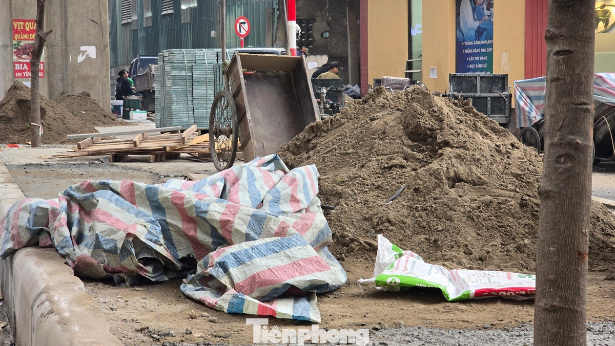 Vật liệu xây dựng được các hộ dân gần đó tập kết lộn xộn, tràn ra lòng đường.