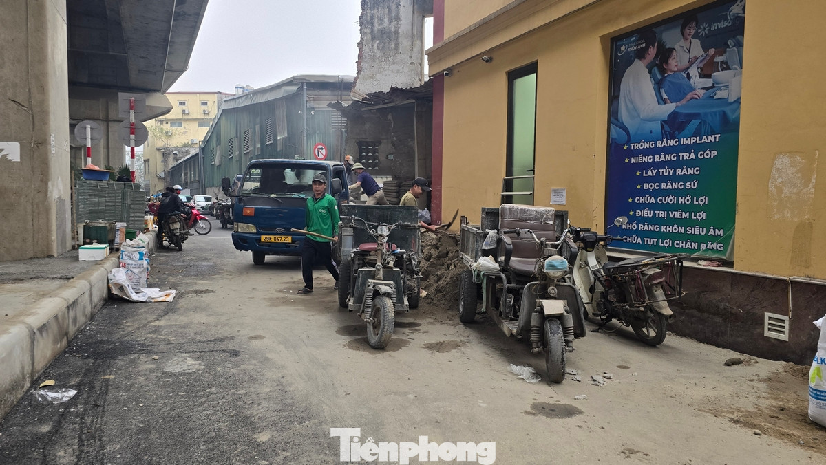 Cả hai phần làn đường đã bị chiếm dụng thành những bãi đỗ xe máy, ô tô. Dải phân cách lớn ngay dưới cầu đường sắt biến thành nơi kinh doanh cà phê.